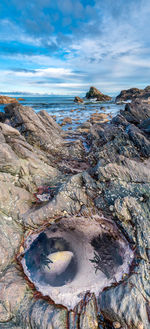 Rock formations on shore against sky