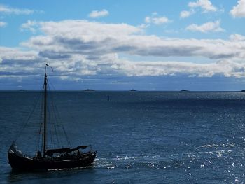 Sailboat sailing on sea against sky