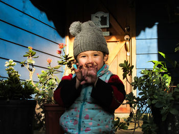 Portrait of cute girl standing against plants