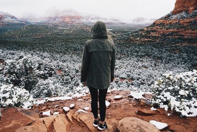 Rear view of woman standing on snow covered mountain