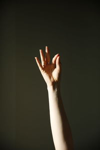 Close-up of woman hand against gray background