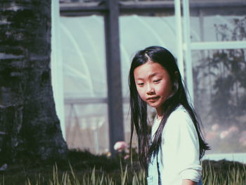 Young woman standing against trees