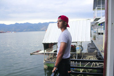 Portrait of senior man standing on boat against mountains