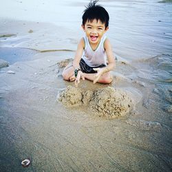 Portrait of smiling boy sitting on beach