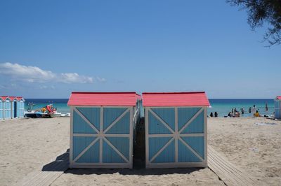 Lifeguard hut on beach against blue sky