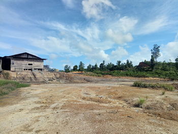 Abandoned building on field against sky