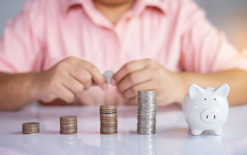 Cropped image of hand holding coins on table