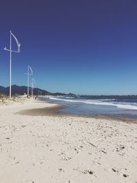 Scenic view of beach against clear blue sky