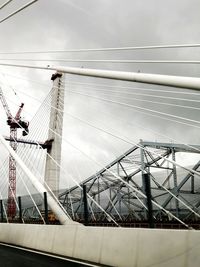 Low angle view of suspension bridge against sky