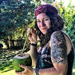 Portrait of young woman having coconut water at park