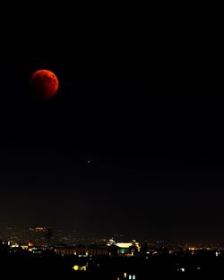 Illuminated city against sky at night