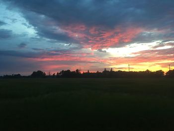 Scenic view of silhouette field against sky during sunset