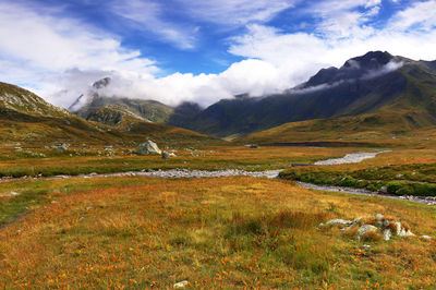 Scenic view of field and mountains against sky