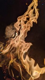 Close-up of burning candle against black background