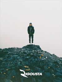 Full length of man standing on field against clear sky