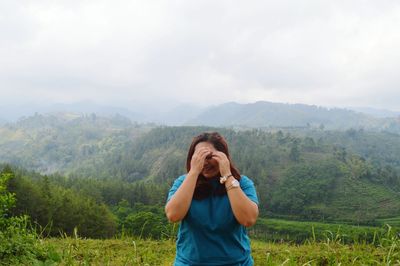 Woman standing on field against mountain