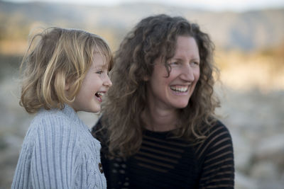 Mother and daughter laughing outdoors