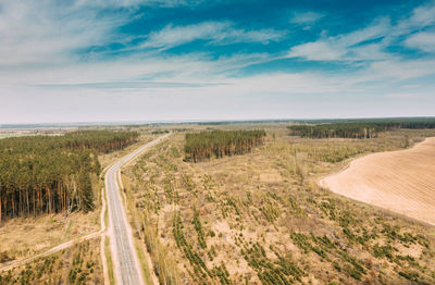 Road amidst field against sky