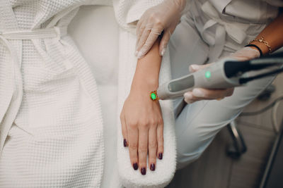 High angle view of woman getting treatment from doctor at hospital