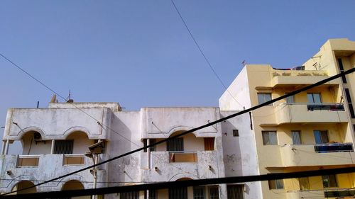 Low angle view of buildings against clear blue sky