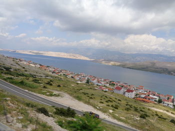 Aerial view of town by sea against sky