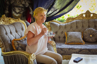 Mature attractive woman traveler sitting alone on the terrace of coffee shop