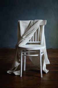 Chair with textile on floorboard at home