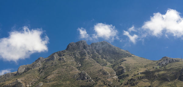 Low angle view of mountain against blue sky