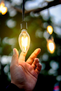 Close-up of hand holding light bulb