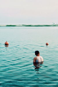 Rear view of shirtless man in swimming pool