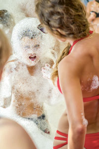 Young boy at the foam party. the face and body are covered with foam. holiday concept.