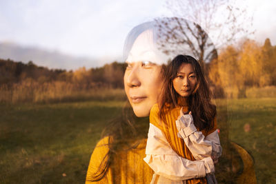Double exposure, beautiful asian woman standing in autumn forest.