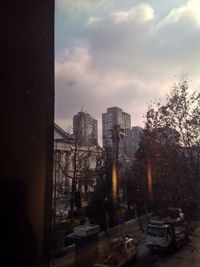 Buildings in city against cloudy sky