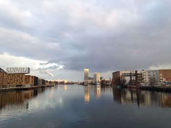 River in city against cloudy sky