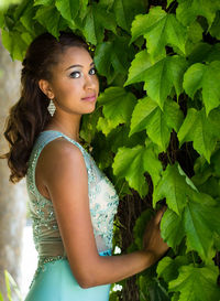 Side view portrait of young woman wearing gown while standing in park