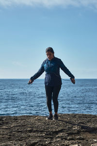 Middle-aged latin woman jumping rope, warmed up for workout, burning calories and keeping fit, 