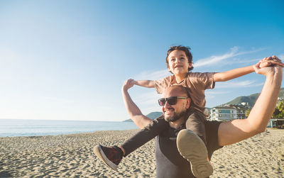 Boy sits on his father's shoulders