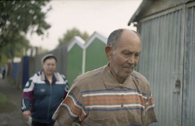 Portrait of man standing by house