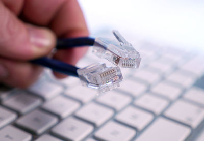 Cropped hand holding computer cables