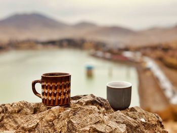 Close-up of coffee cup on table against wall