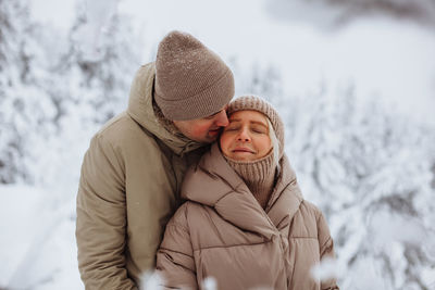 Loving couple hugging in the winter forest