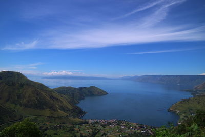 Scenic view of sea and mountains against blue sky