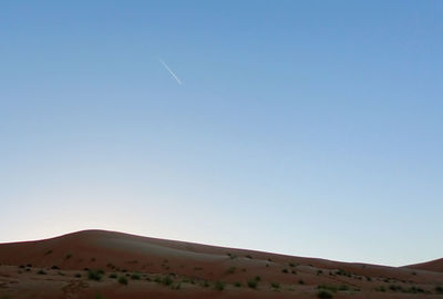 Scenic view of desert against clear blue sky