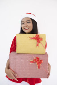 Portrait of smiling young woman against white background