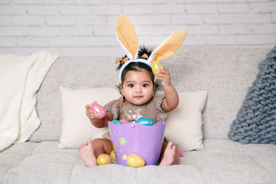 Cute girl wearing costume sitting on sofa