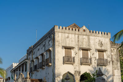 Low angle view of buildings against clear blue sky