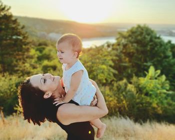 Side view of mother and daughter outdoors