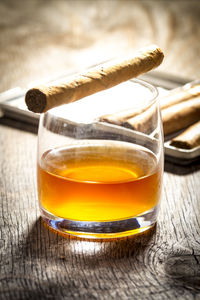 Close-up of cigar on whiskey at table