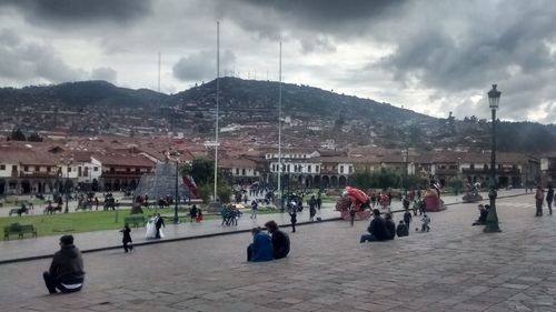 People on mountain against cloudy sky