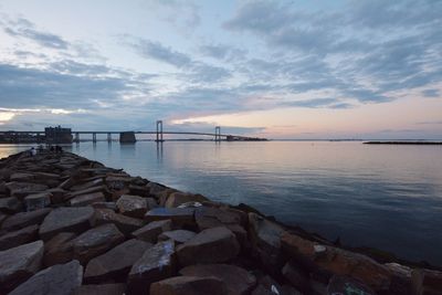Scenic view of sea against cloudy sky during sunset